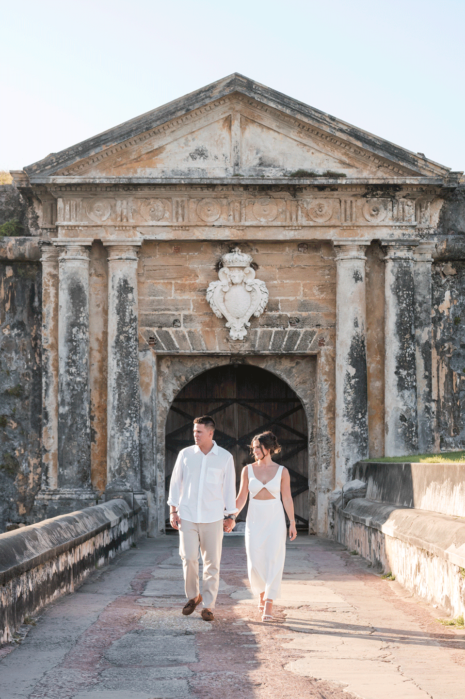 Couple walking through historic entrance at Old San Juan engagement session Puerto Rico