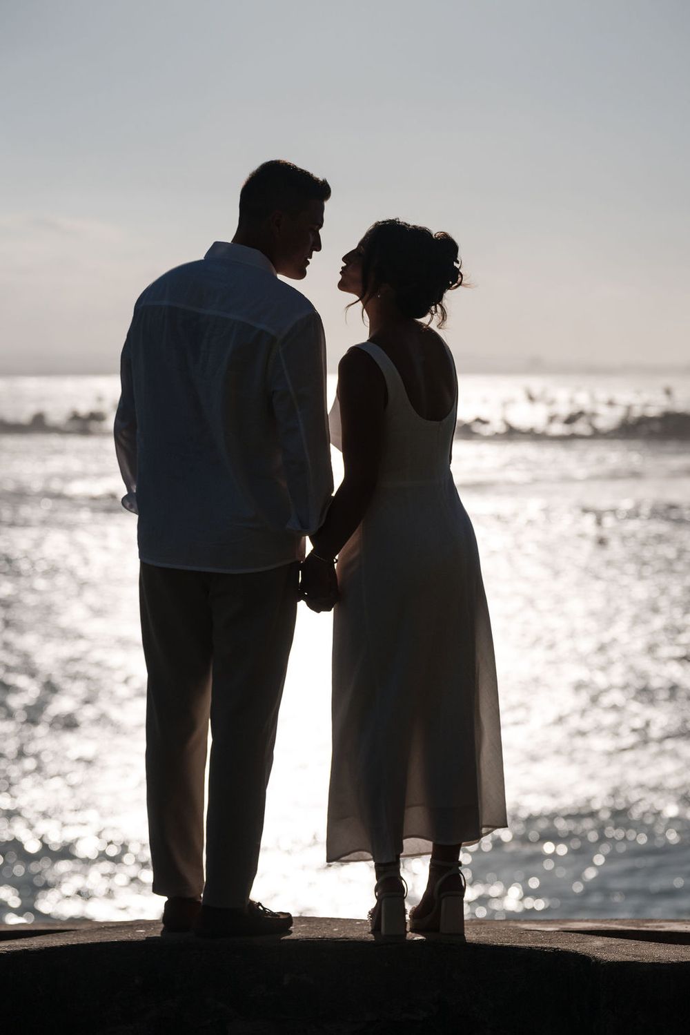 Couple standing by the ocean during sunset engagement session in San Juan Puerto Rico