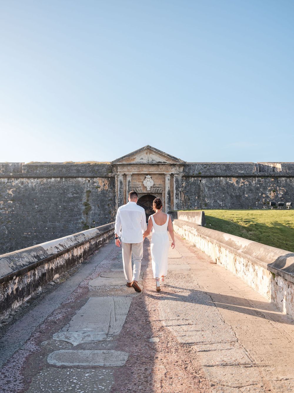 Bride walking along fortress wall at Old San Juan during engagement session