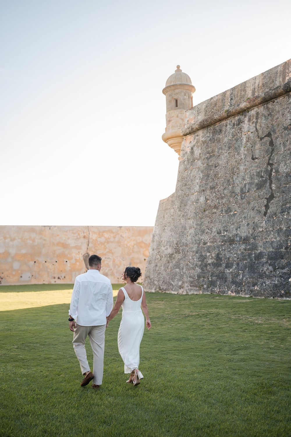 Couple walking along fortress wall in Old San Juan Puerto Rico engagement session