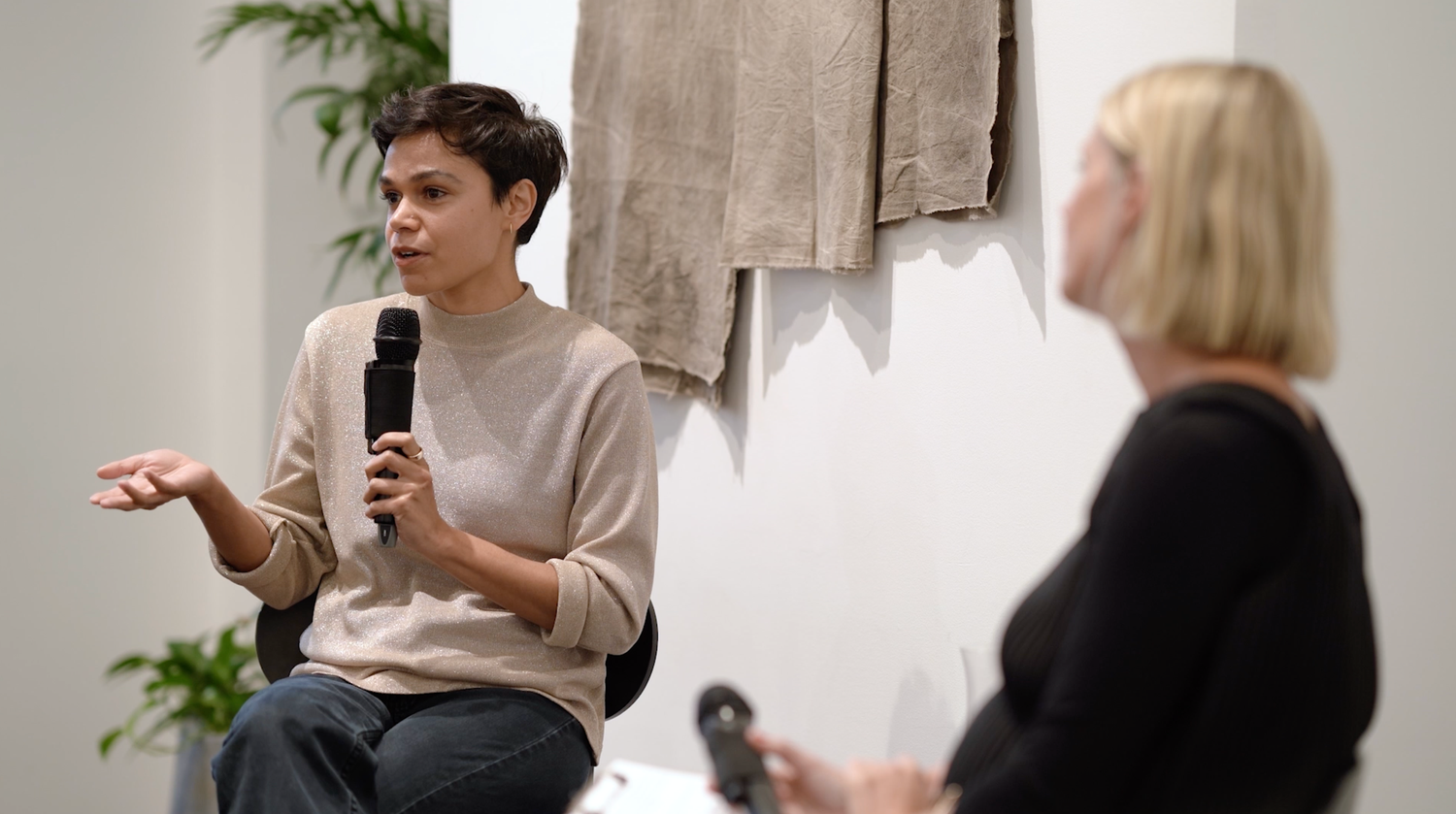 People interacting in a modern white gallery or exhibition space.