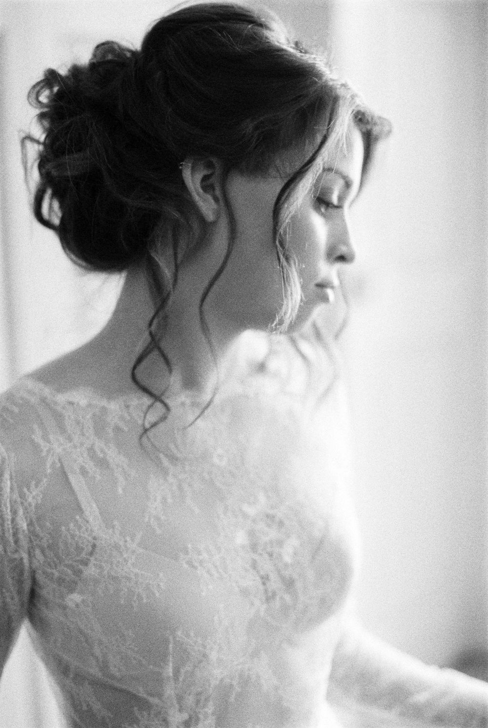 A series of black and white photos showing the delicate lace details of a wedding dress in soft natural lighting.