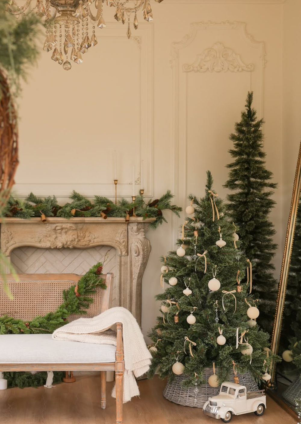 Festive Christmas scene with decorated trees, white chaise lounge, and vintage toy car in an ornate room.