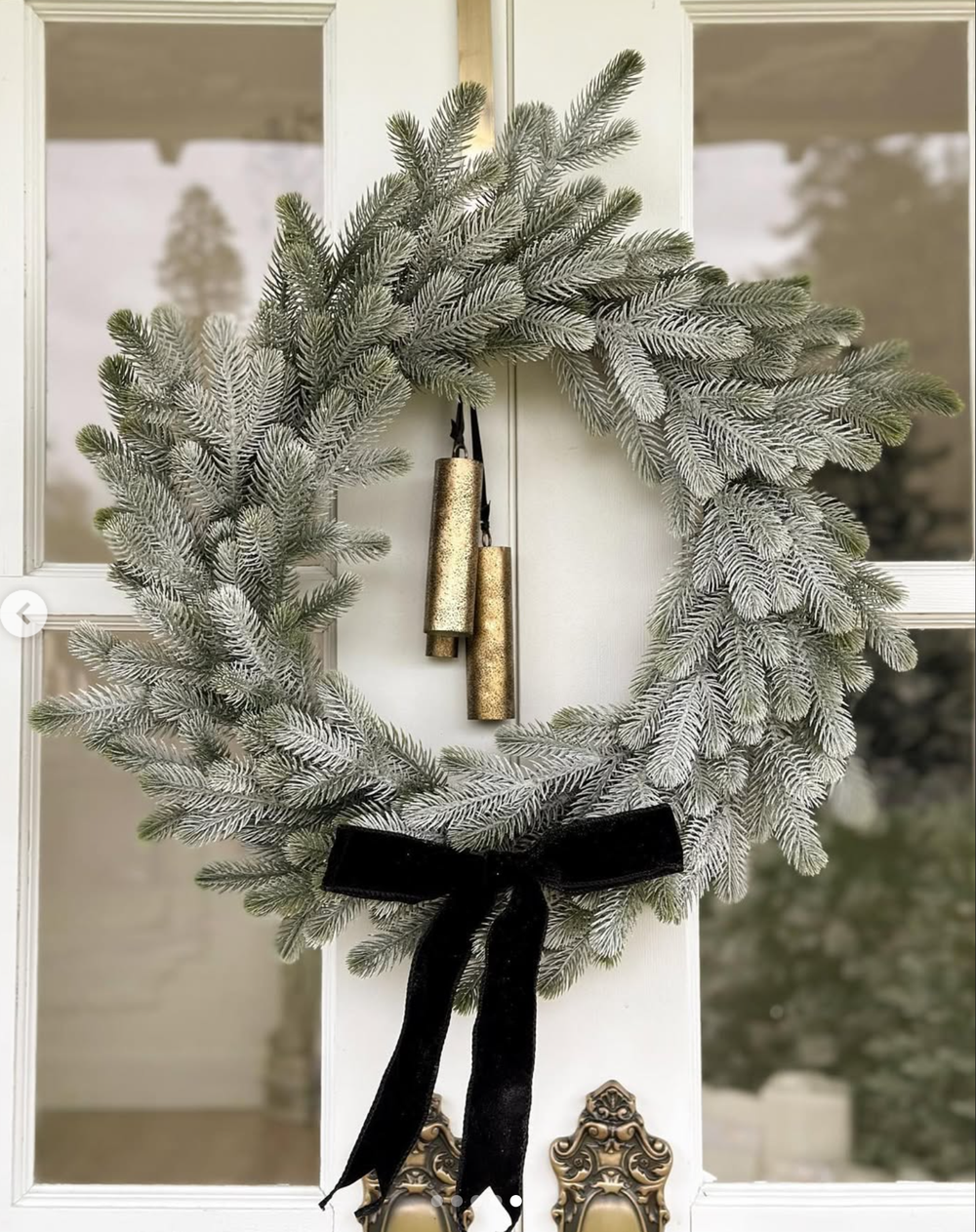 Step by step process of making a frosted Christmas wreath with a black velvet bow and pine cones for decoration.