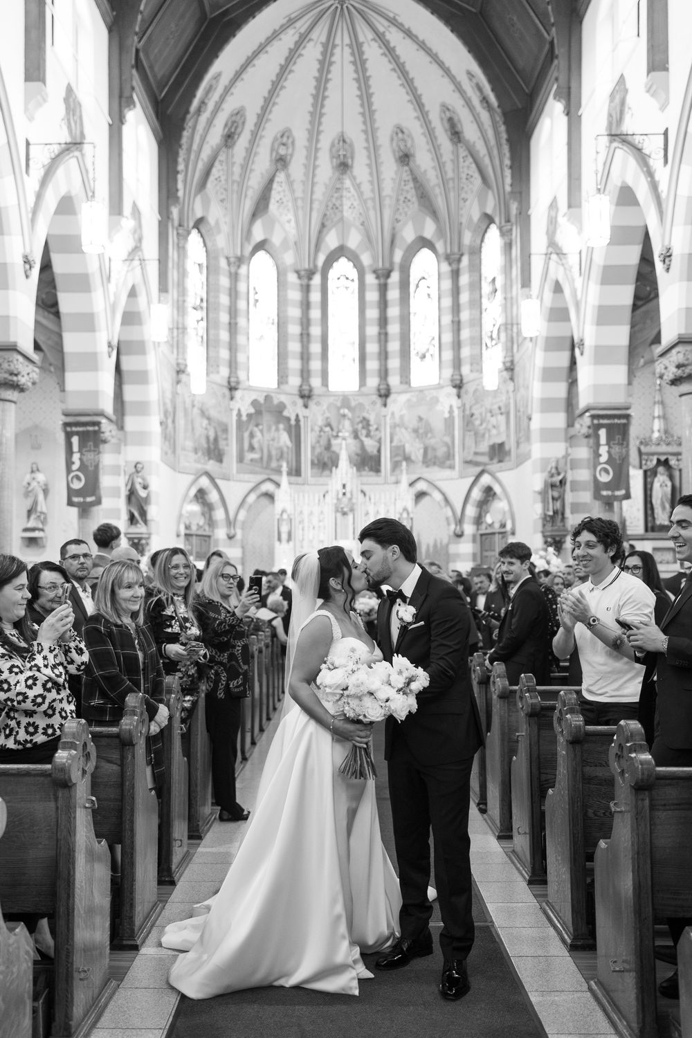 A romantic wedding ceremony takes place in a stunning Gothic cathedral with soaring vaulted ceilings and ornate architecture.