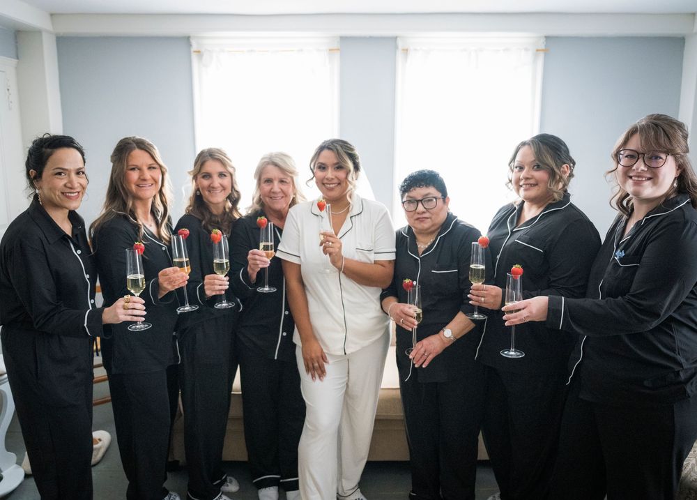 Group celebrating with champagne glasses in matching black attire.