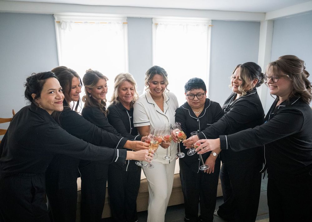A group of people in formal attire joining hands in a circle during a celebration event.
