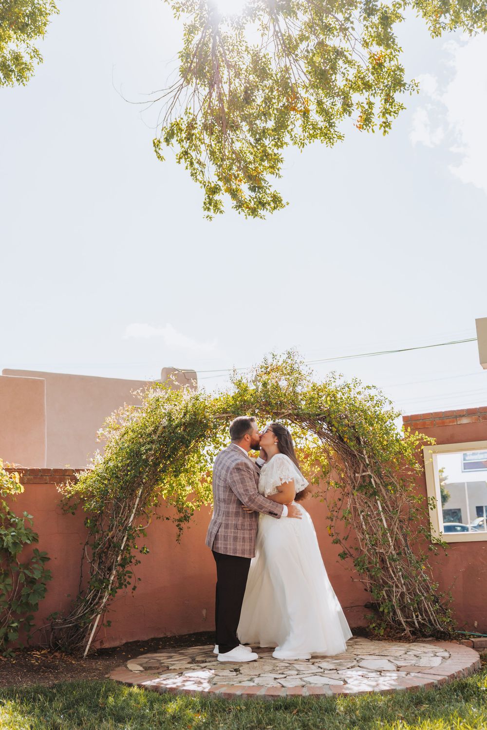 A romantic outdoor wedding photo sequence showing a couple in a garden setting with terracotta walls and green trees.