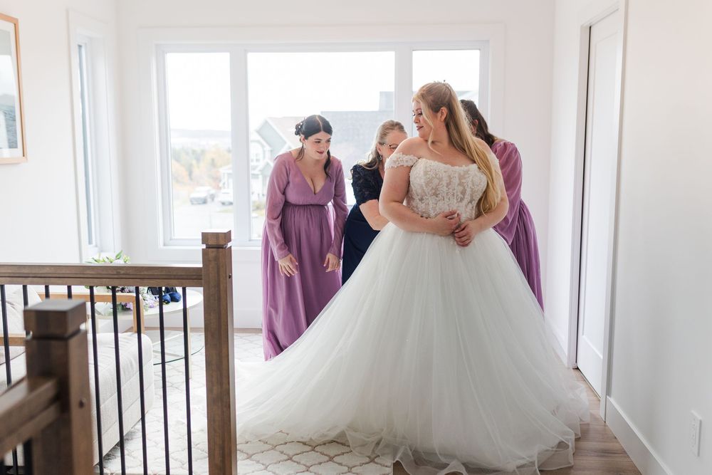 Elegant white ballgown wedding dress with lace bodice in a sunlit room.