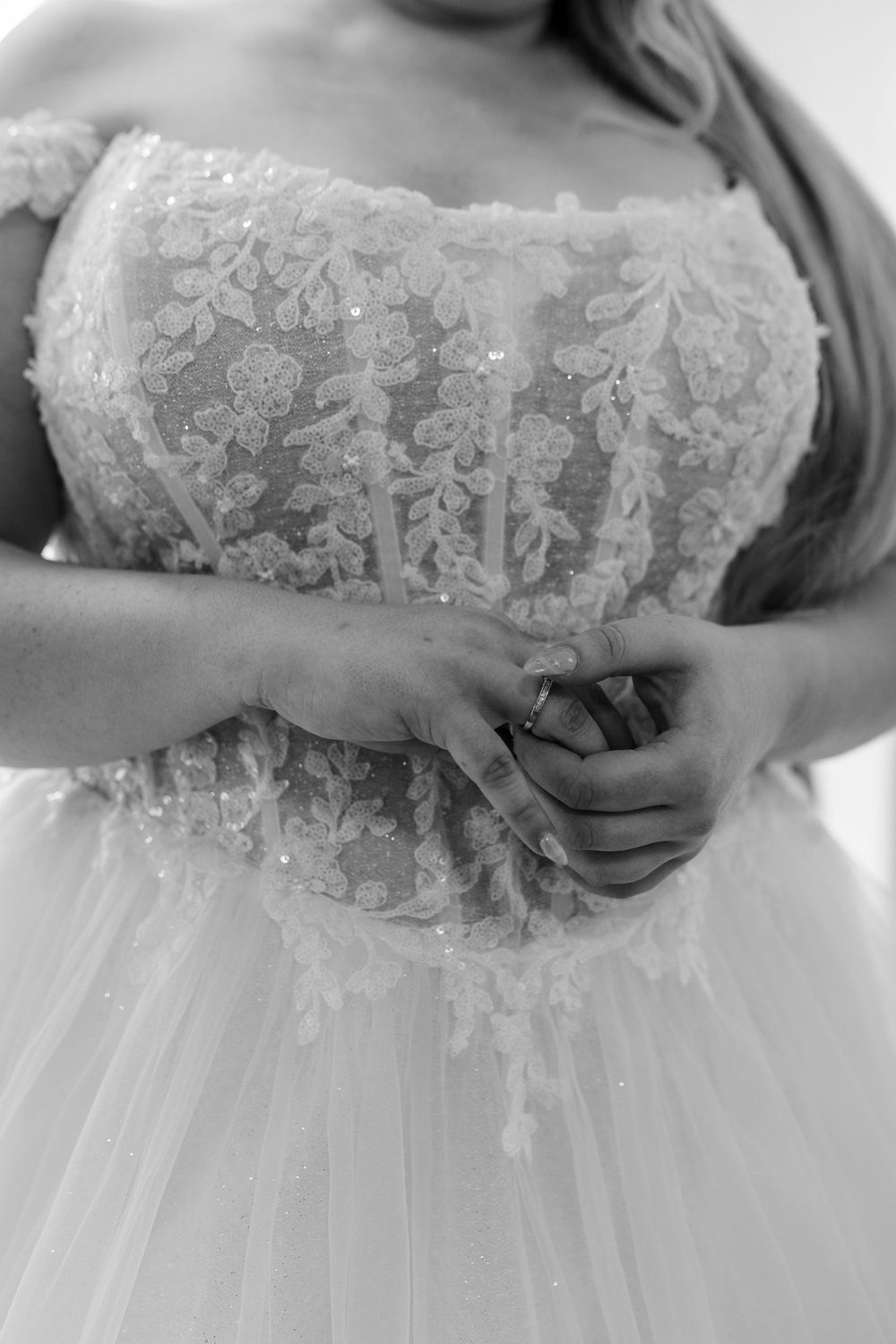 Close-up details of delicate white lace and tulle fabric on a wedding dress bodice.
