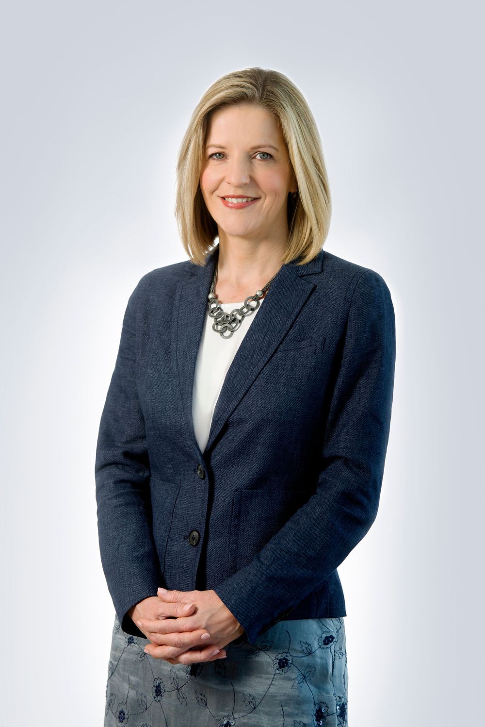 Professional portrait series showing woman in navy blazer against light background.