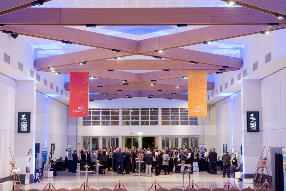 Large modern event space with blue accent lighting and high ceilings.