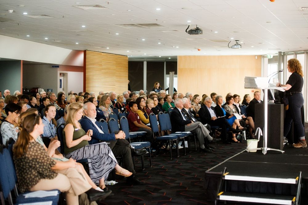 Corporate conference room filled with attendees during presentation.
