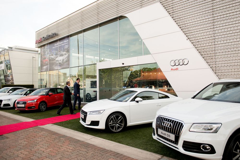 Modern Audi dealership exterior showcasing luxury vehicles on display.