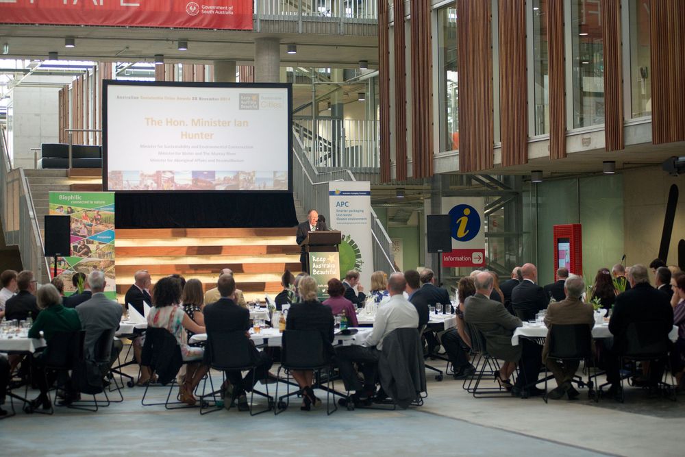 Corporate event setup with projection screen and round tables for audience seating.