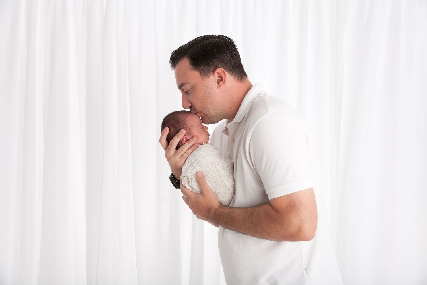 Person in white shirt showing intense emotional distress against white curtained backdrop.