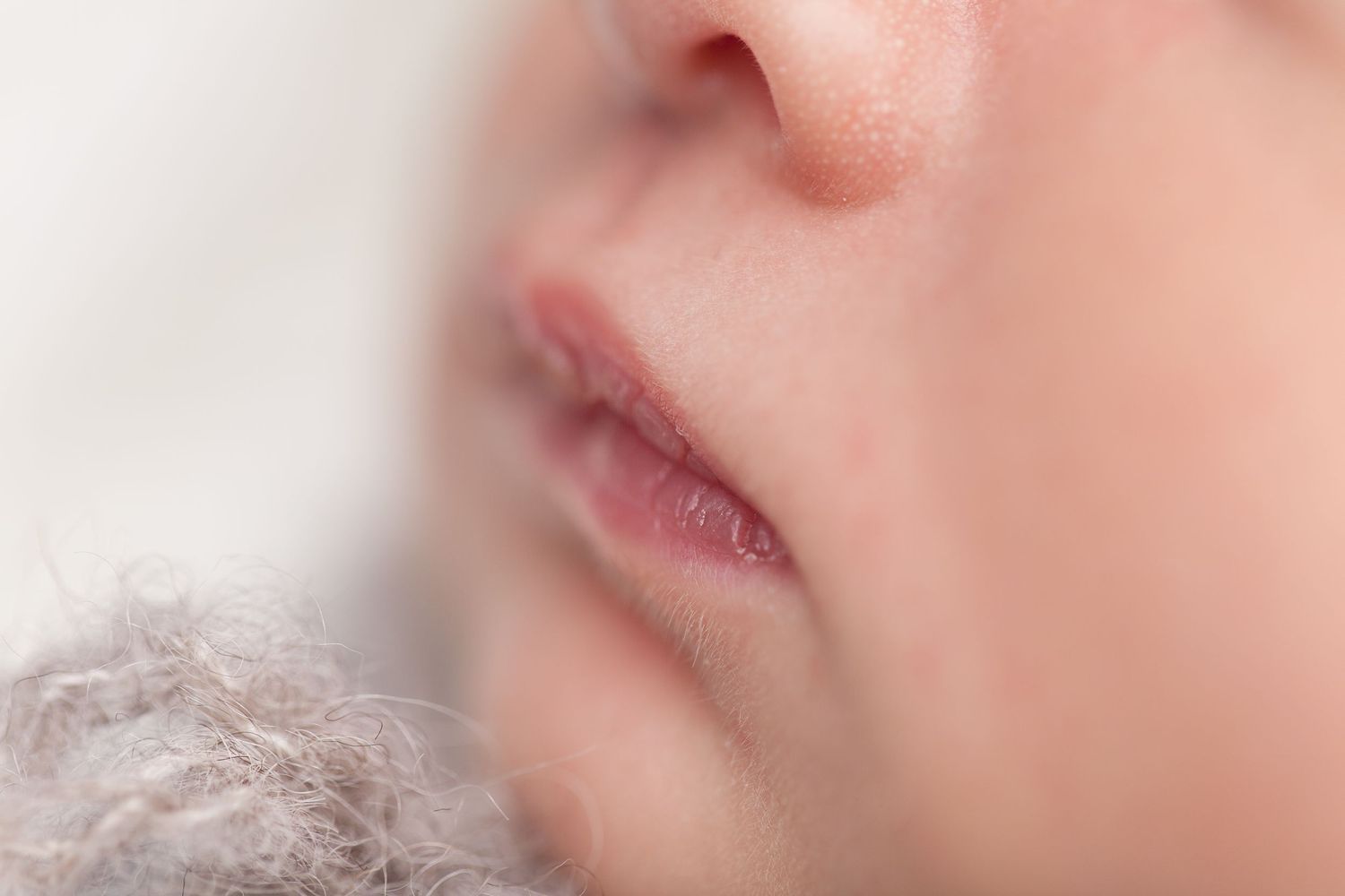 Close-up macro shot showing pink lips and skin texture with soft focus and natural lighting.