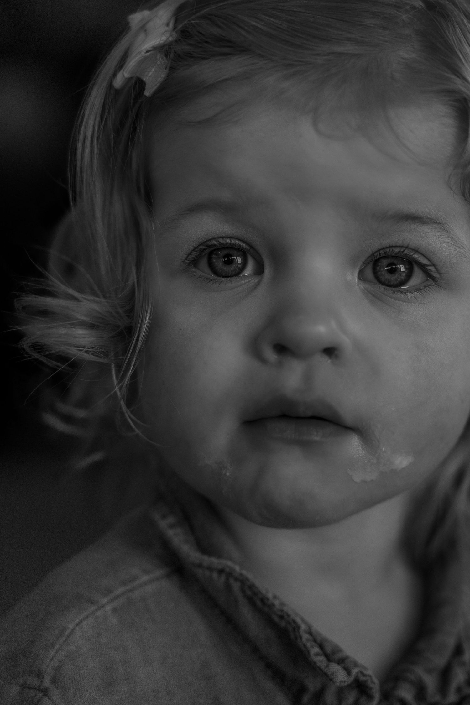 A series of black and white close-up portraits showing different expressions and angles of a young child's face.