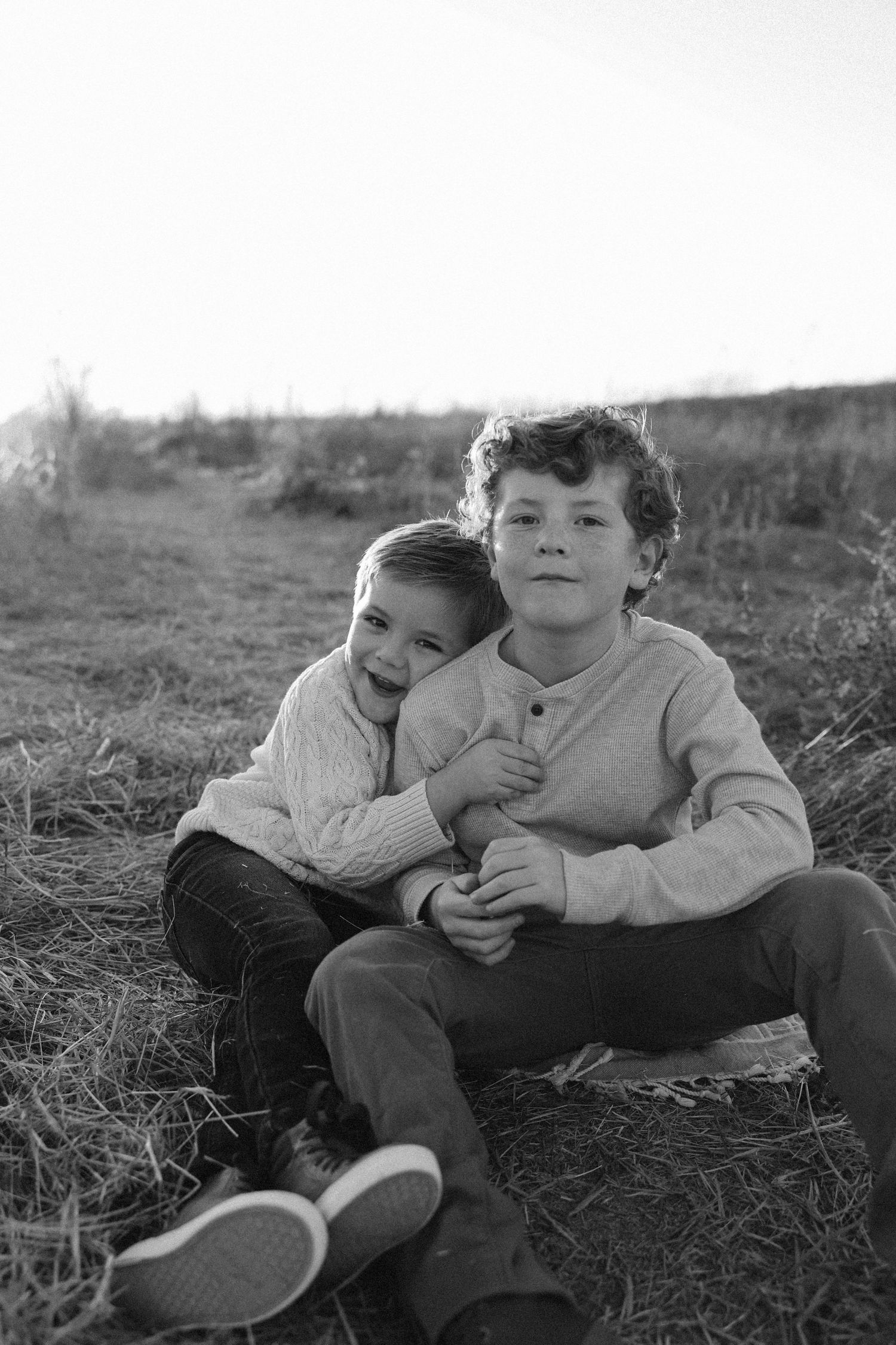 Orange County photographer capturing brothers snuggling during golden hour