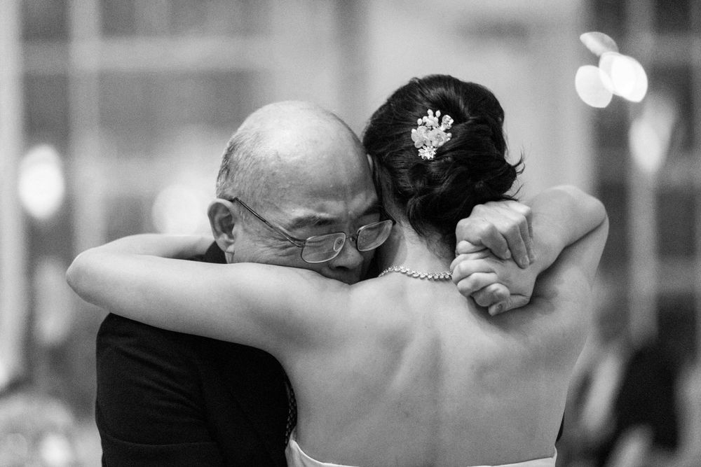Emotional black and white photo of bride sharing heartfelt dance with her father at wedding.
