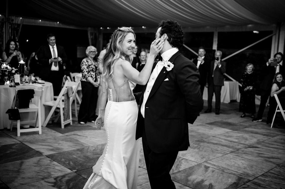 Black and white photo of bride and groom sharing their first dance at wedding reception.