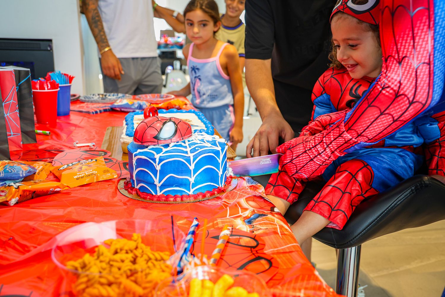 Spider-Man themed party setup with red decorations and activities for children.
