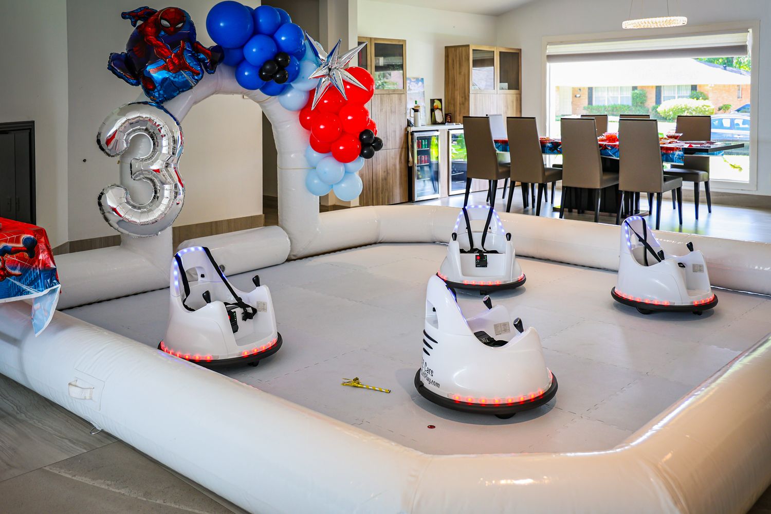 Modern event space decorated with balloons and featuring Spider-Man themed entertainment.