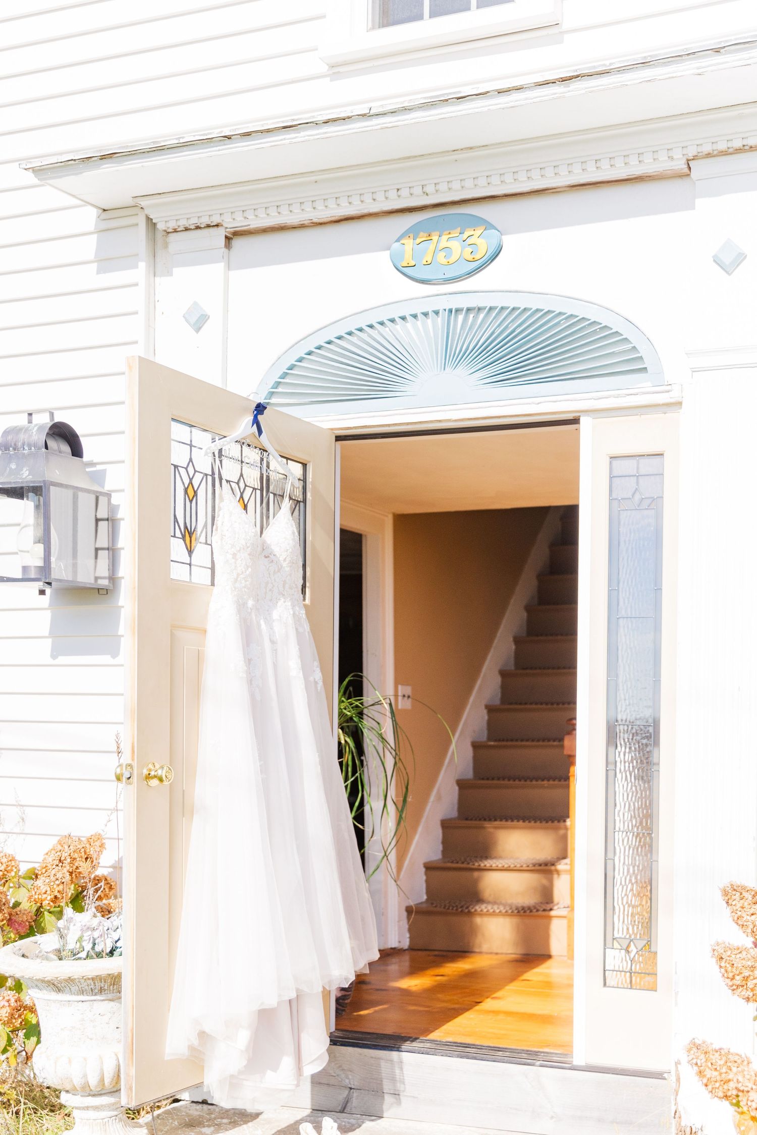 Wedding dress displayed in white doorway entrance with fanlight window above.