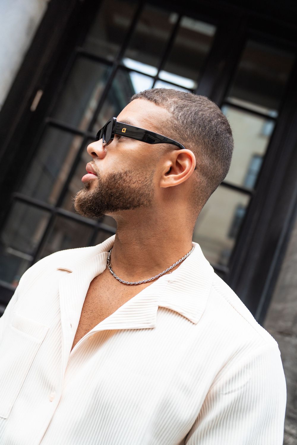 Side profile portrait in white ribbed shirt and sunglasses against dark window. Mtlshutter photography