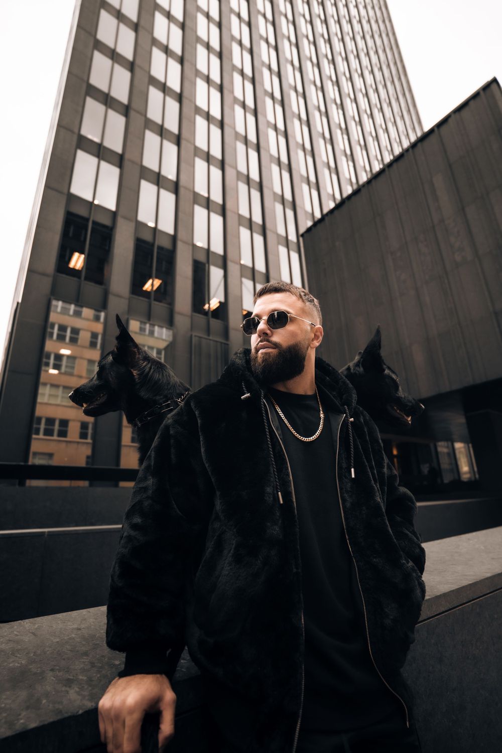 Street style portrait in black winter wear against modern skyscraper backdrop. Mtlshutter photography
