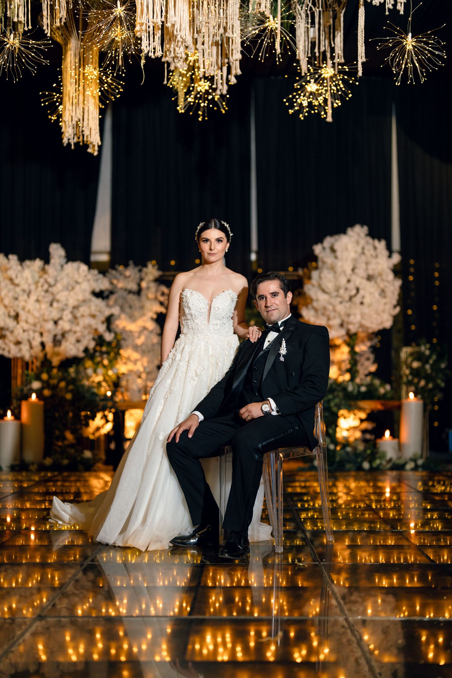 Elegant wedding reception setup with hanging crystal decor and glowing candles creating romantic ambiance.