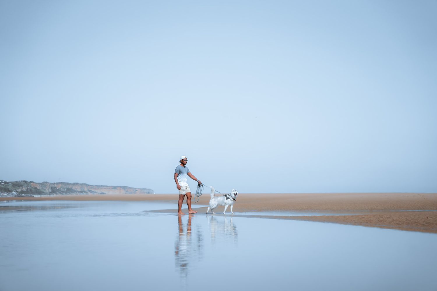 Promeneur et son chien à Utah beach, plage du débarquement dans le département de la Manche en Normandie - Cotentin.