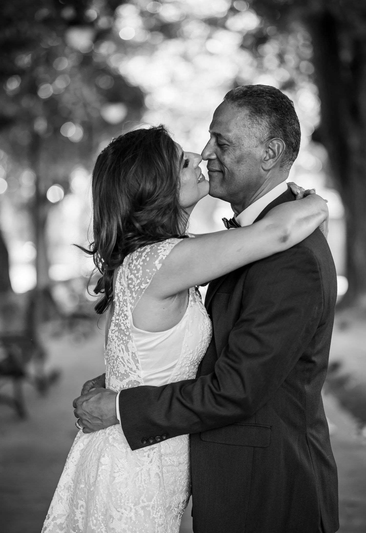 Black and white portrait of newlyweds sharing an intimate moment outdoors.