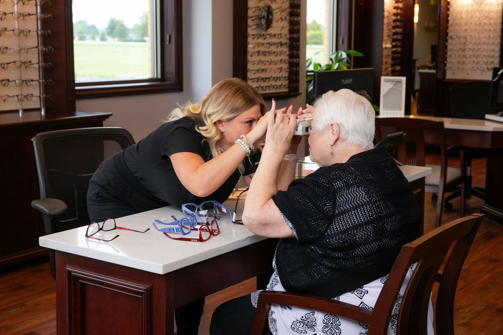 Eye care professional conducting vision test with patient at optical store.