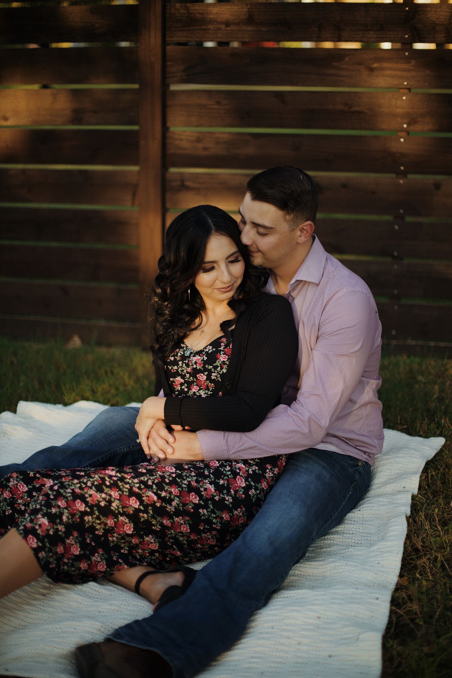 Couple embracing each other while on a picnic table.