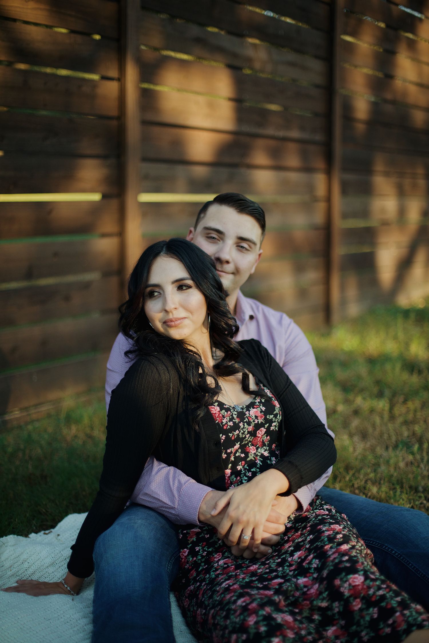 Couple hugging each other while staring off into the distance.