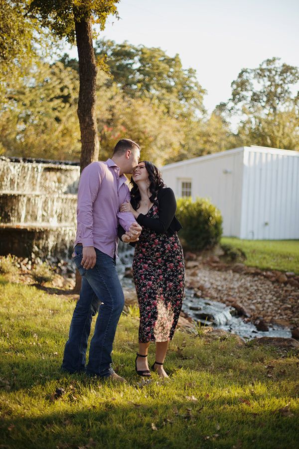 Couple kissing and walking near a waterfall.