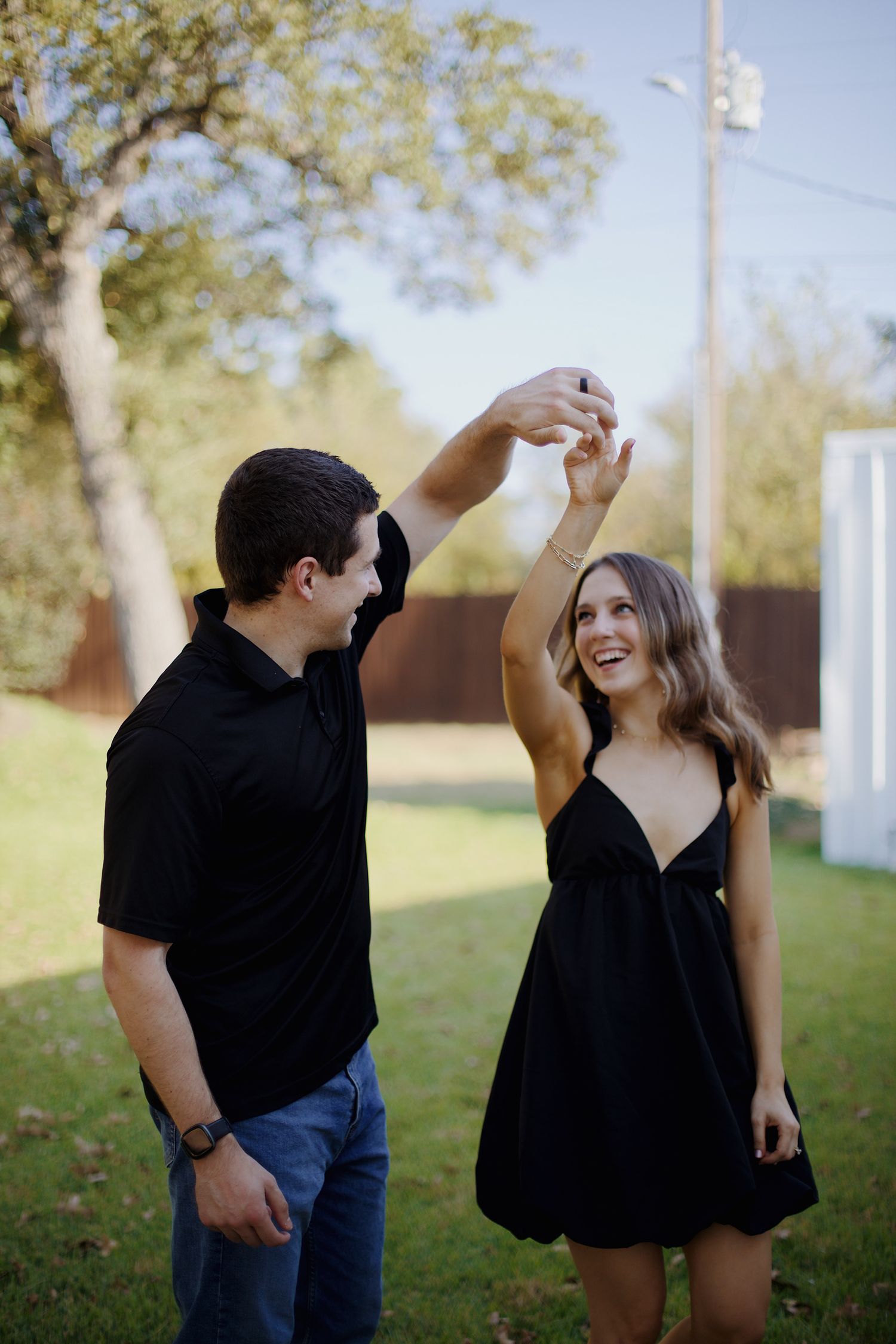 Engaged couple dancing and twirling together.