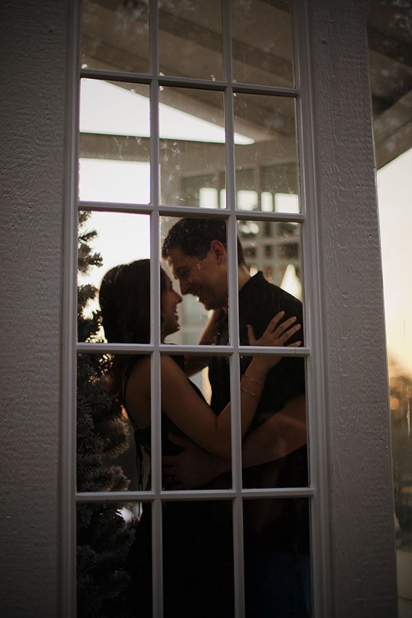 Intimate couple portrait staring at each other in a glasshouse.