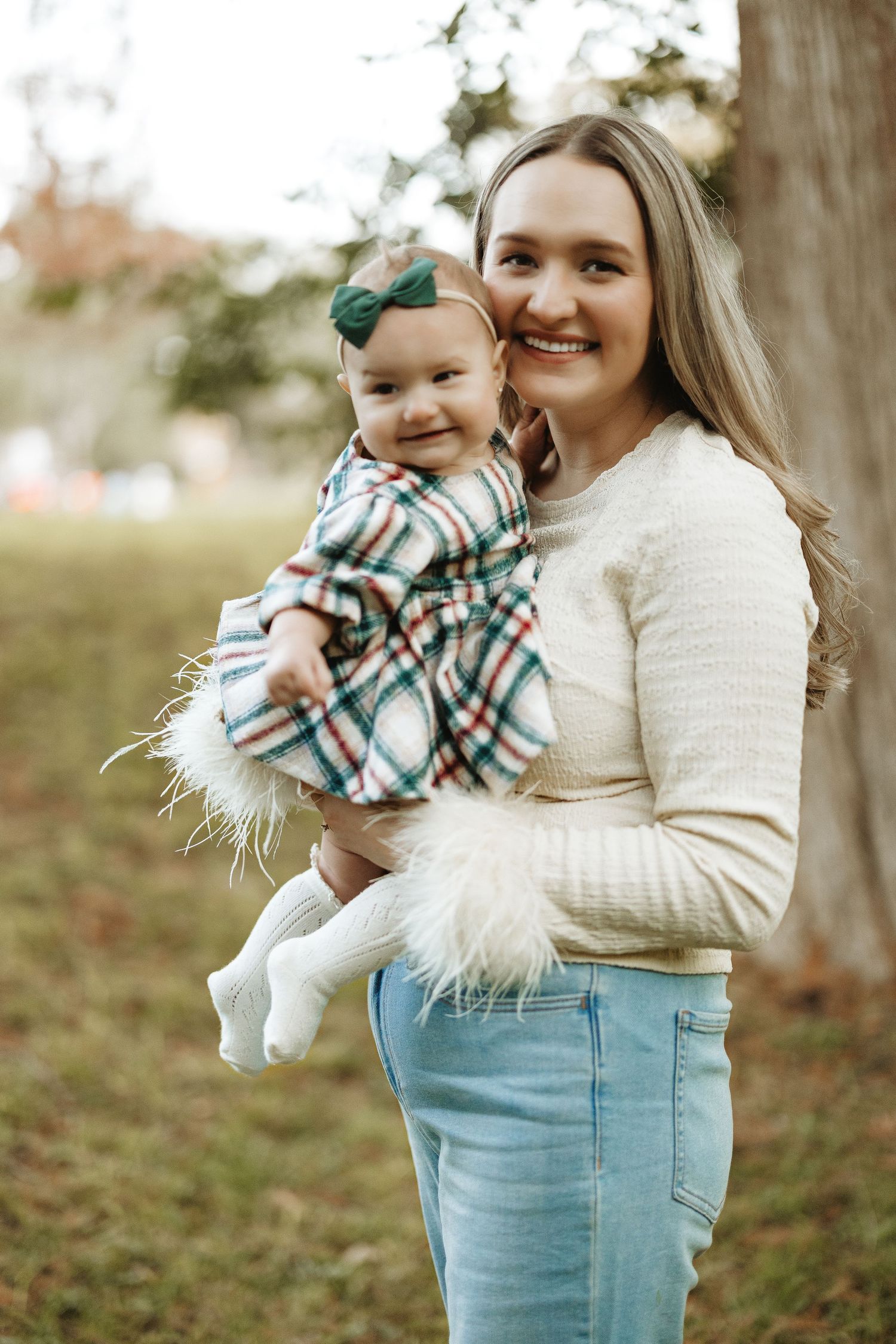 A candid outdoor family portrait featuring warm sweaters and plaid dress against a natural autumn backdrop. Motherhood, mother and daughter,