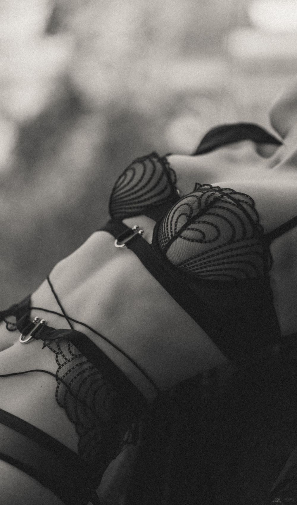 Close-up black and white photo of intricate lace lingerie details.