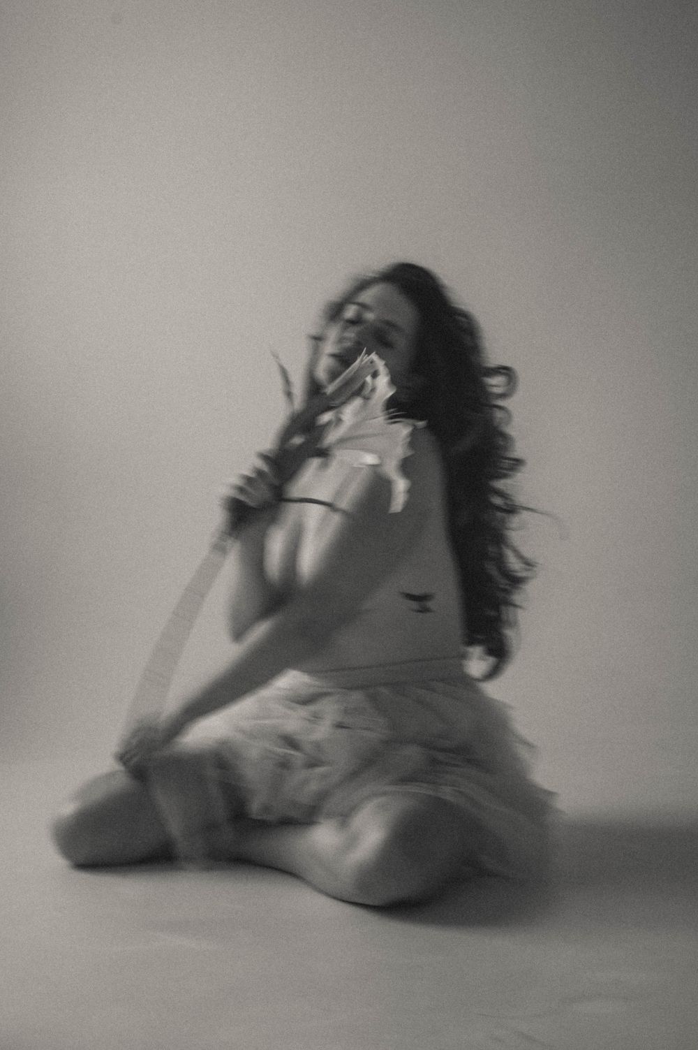 Ethereal black and white portrait showing movement with flowing fabric and hair.