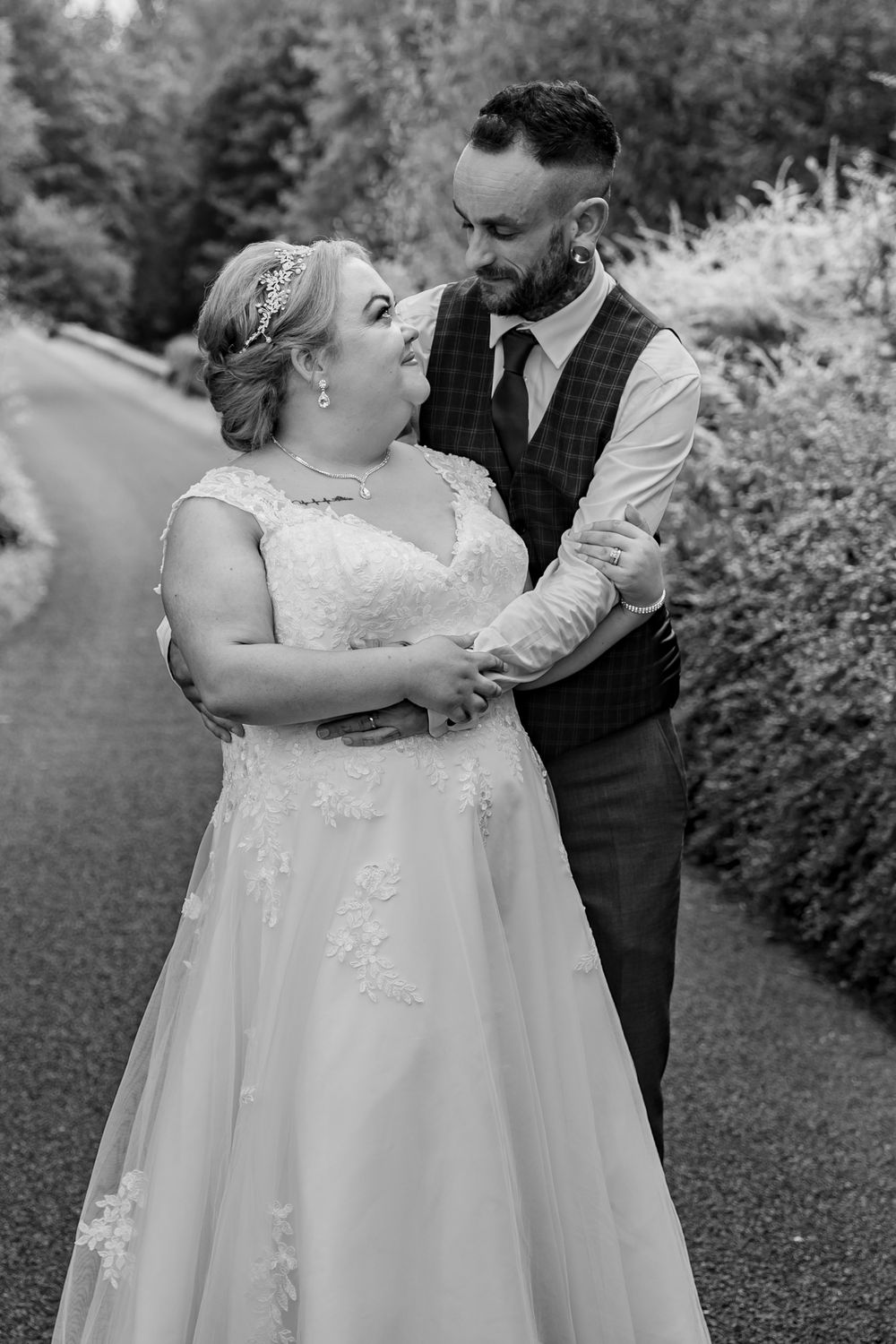 Black and white wedding photography capturing romantic dance poses in a garden.