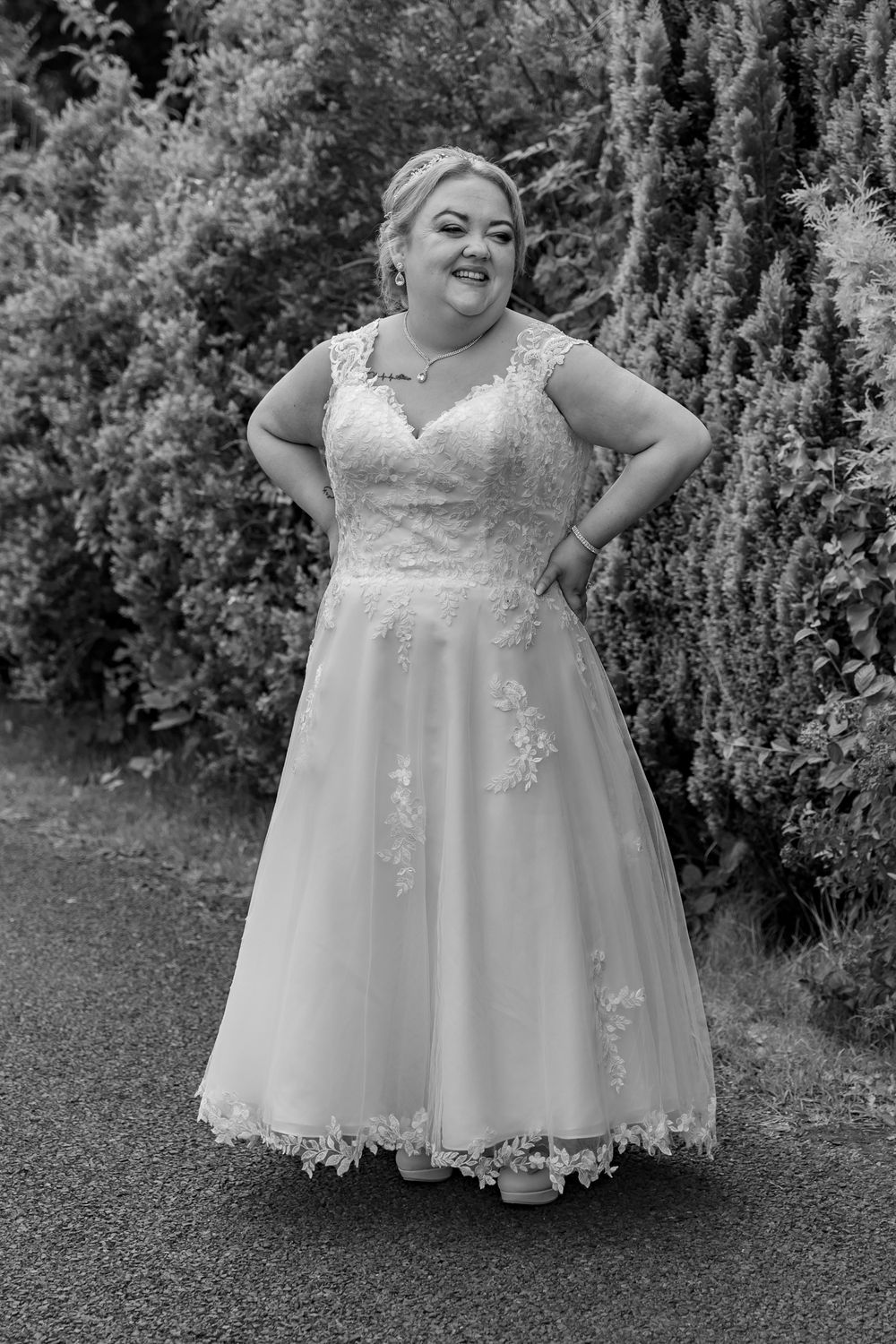 Elegant bridal portraits showcasing detailed lace wedding gown in a garden setting.