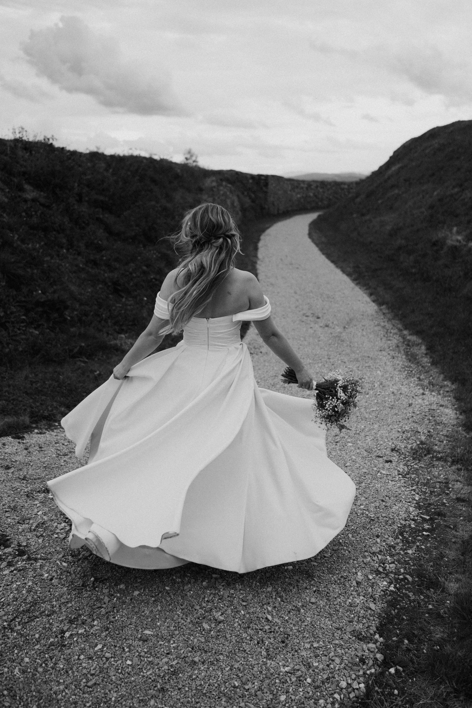 A black and white sequence shows a bride in a flowing white dress twirling on a mountain path.