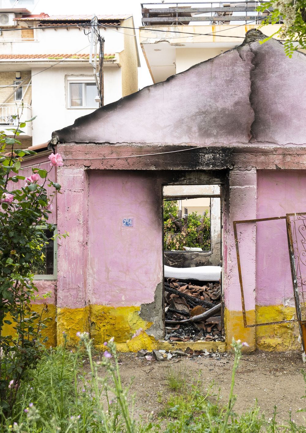 Sequence of pink and yellow painted concrete garages showing progressive deterioration and damage over time.