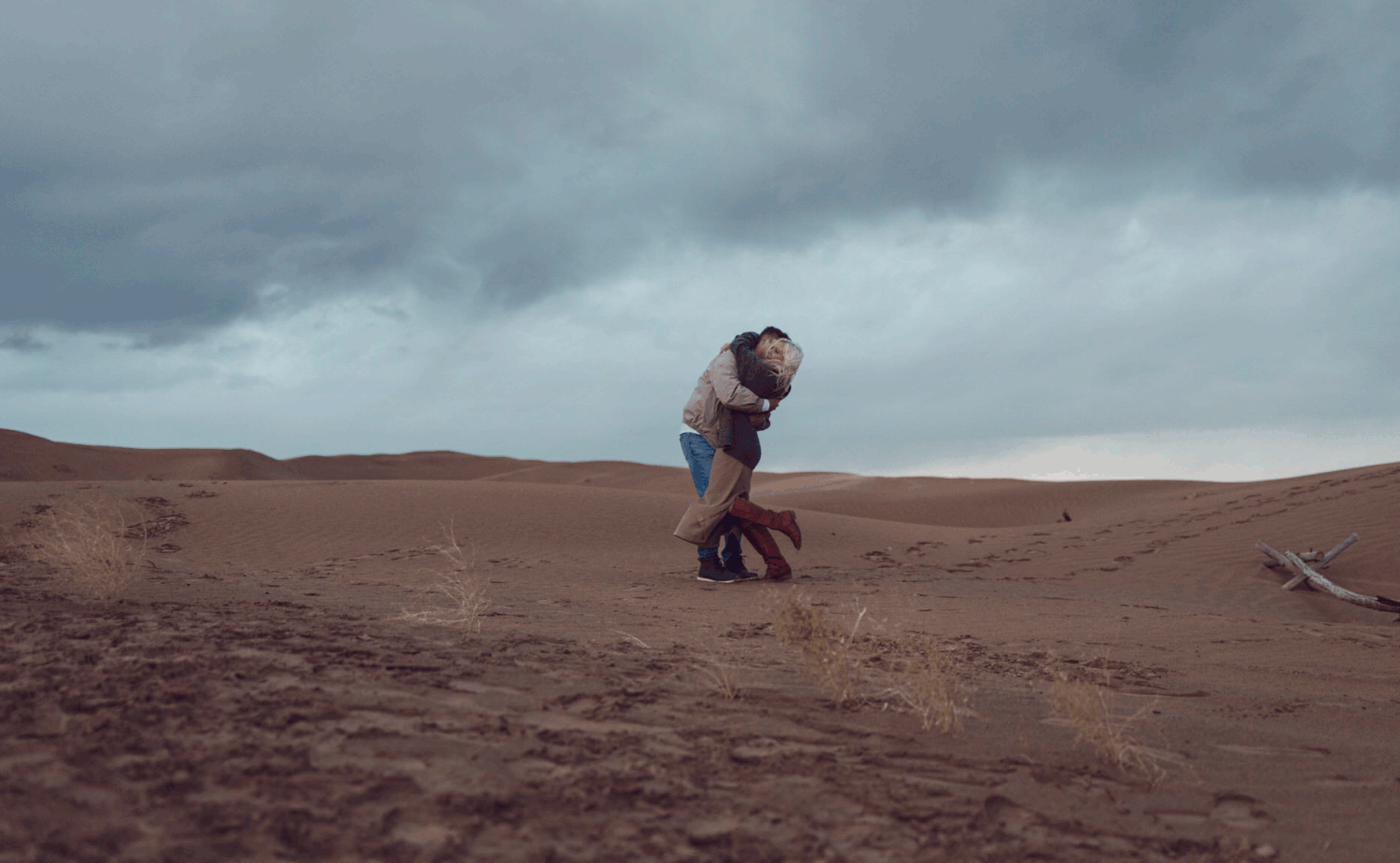 spring beach engagement session, GIF of couple spinning in circles with a moody sky in the background.