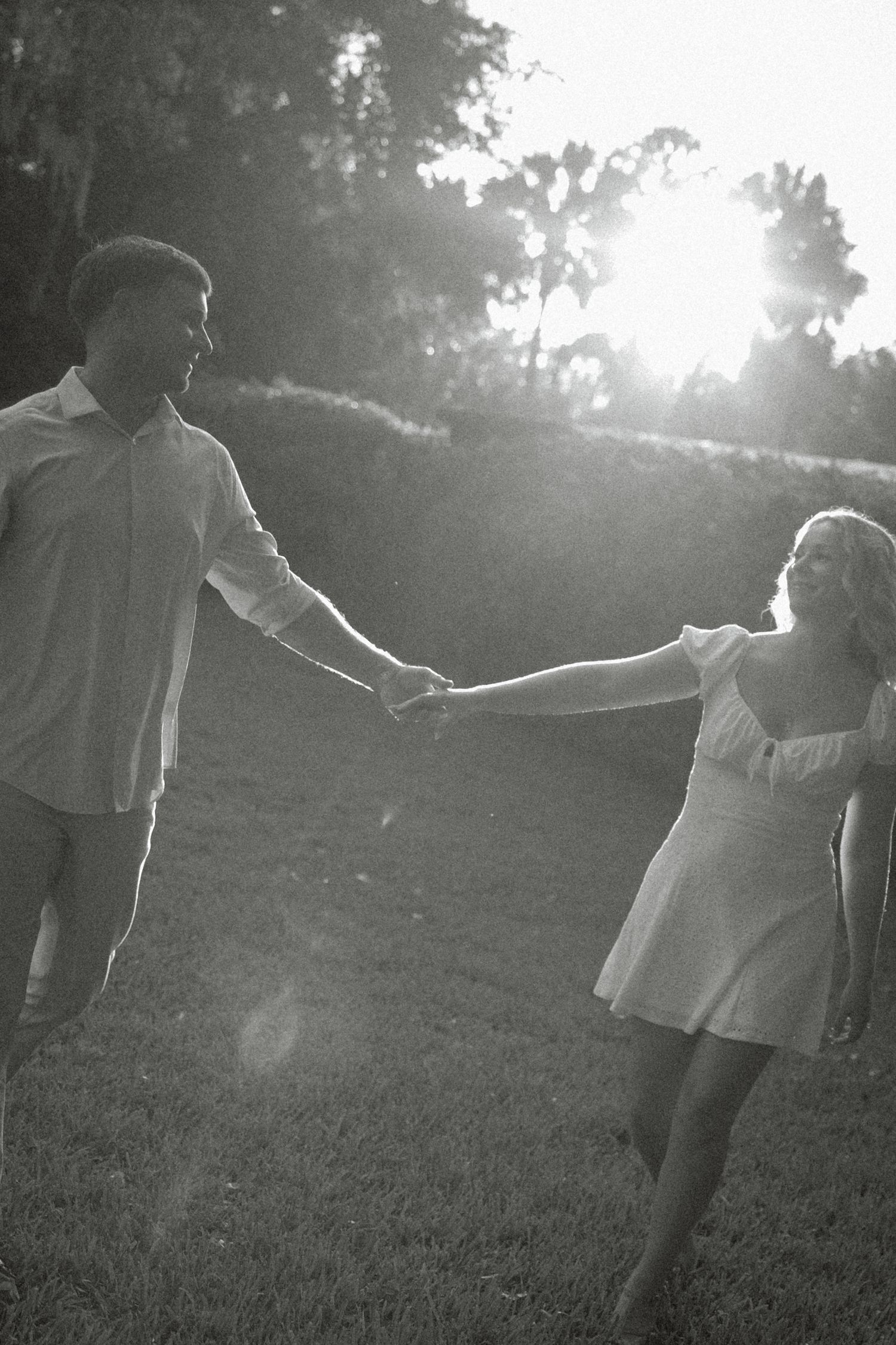 Wedding party in burgundy dresses creates motion blur effect around bride and groom outdoors.