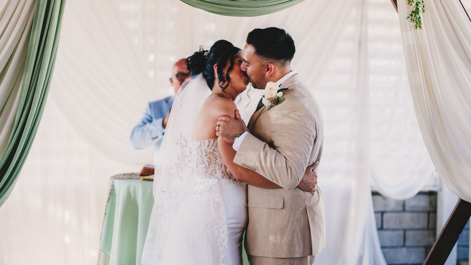 A collage of wedding moments showing couples embracing and dancing under elegant white drapes and soft lighting.