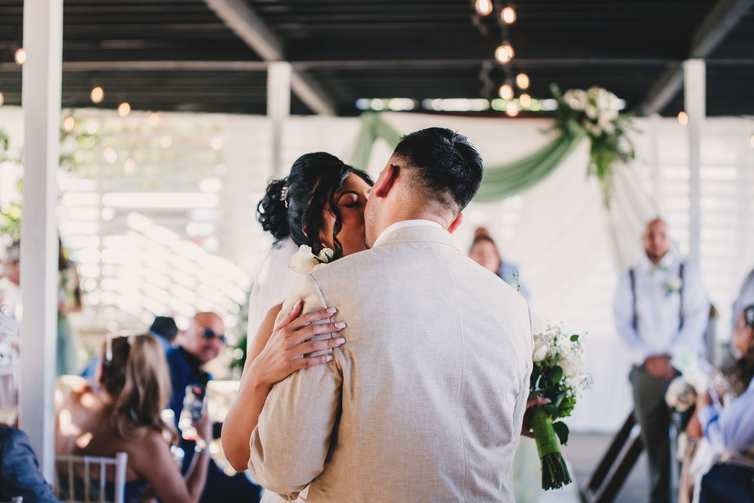 Guests dance and celebrate on an illuminated dance floor during an evening wedding reception.